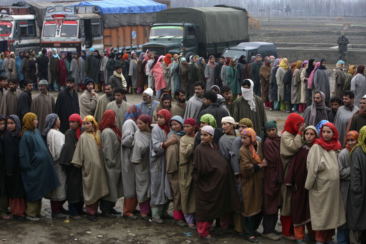 Kashmiri Muslims wait to cast their vote outside a polling station in Veeri some 47 kilometers (29 miles) south of Srinagar, India, Wednesday,  Dec. 17, 2008.  Voters headed to the polls in dozens of towns in Indian Kashmir on Wednesday as security forces lined the roads and Muslim protesters boycotted the elections. (Dar Yasin / AP)