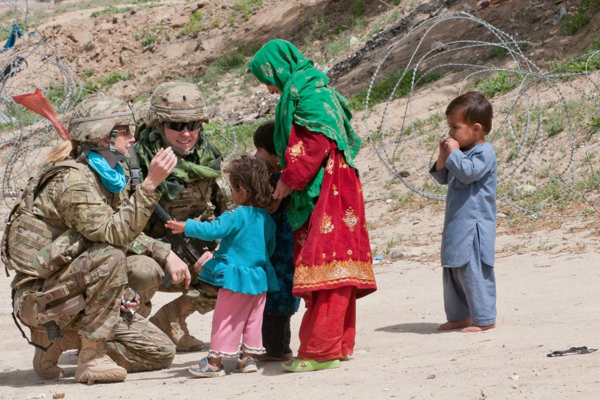 Elizabeth Trobaugh, second from left, speaks to an Afghan woman about medical education classes in 2012. Trobaugh, a Mt. Spokane High School graduate, was among the first officers to lead a Female Engagement Team in Afghanistan as part of counterinsurgency efforts there.