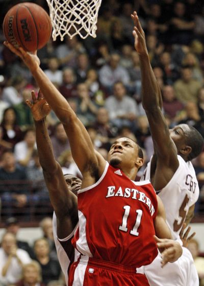 Eastern’s Cliff Colimon shoots in front of Montana’s Keron DeShields, left, and Will Cherry in the first half. (Associated Press)