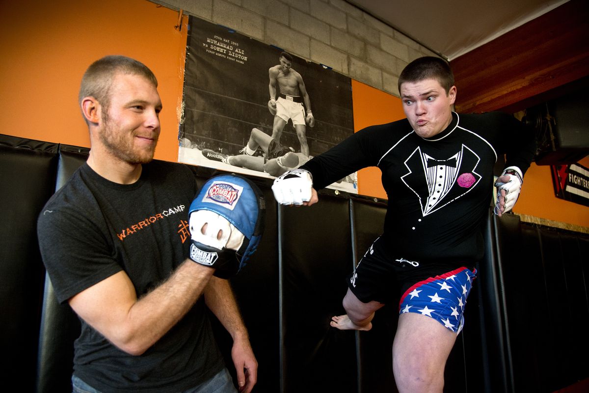 Joel Thomas, left, has developed an app that lets fans of mixed martial arts support and fund a desired move or set of moves to be done by a live-action fighter. Nick Masonholder, right, unsuccessfully tried the “showtime” move last week during competition. (Dan Pelle)
