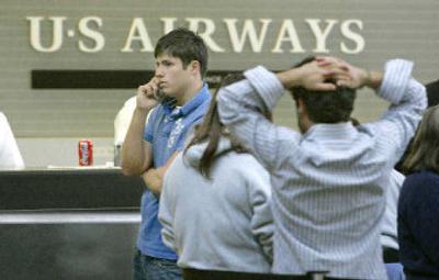 
US Airways patrons talk as they stand in line at the ticket counter at Greater Pittsburgh International Airport last week. 
 (The Spokesman-Review)