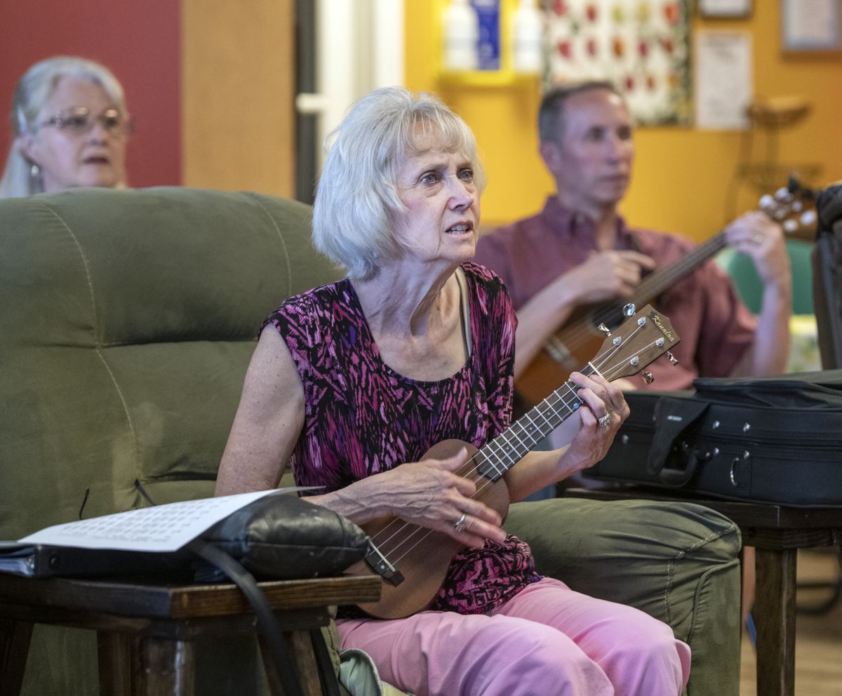 Linda Shane, center, and other members of the ukulele club, play at the On Site for Seniors center in Coeur d’Alene and watch videos with words and chords to learn a new song Tuesday. The group is growing quickly.  (JESSE TINSLEY)