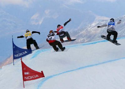 Nate Holland, left, moves into first place in the final round of a snowboardcross World Cup event at Saas-Fee in the Swiss Alps on Oct. 22.
 (Courtesy of Rebecca Holland / The Spokesman-Review)