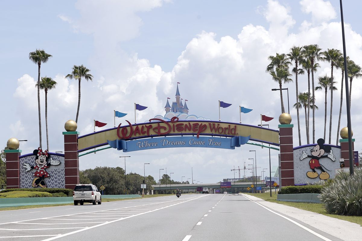 Cars drive under a sign greeting visitors near the entrance to Walt Disney World, Thursday, July 2, 2020, in Lake Buena Vista, Fla. Despite a huge surge of Floridians testing positive for the new coronavirus in recent weeks, Magic Kingdom and Animal Kingdom, two of Disney World