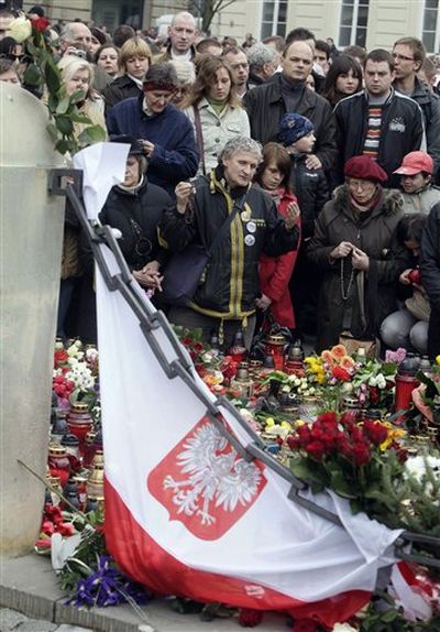 People mourn in front of the Presidential Palace in Warsaw, Poland, Saturday after Polish President Lech Kaczynski died in a plane crash. Kaczynski, his wife and some of the country's highest military and civilian leaders died on Saturday when the presidential plane crashed as it came in for a landing in thick fog in western Russia, killing 96. (Czarek Sokolowski / Associated Press)