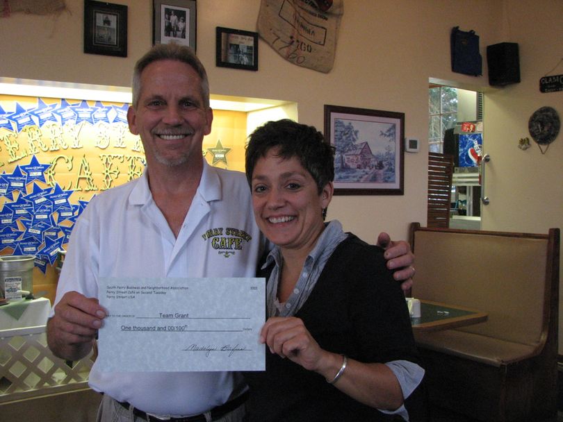 South Perry Cafe owner Geoff White and Grant Elementary teacher Kris Gladeau hold the $1,000 check that was donated to Grant Elementary's library program from the proceeds of the 2010 South Perry Fair and Parade. (Pia Hallenberg)