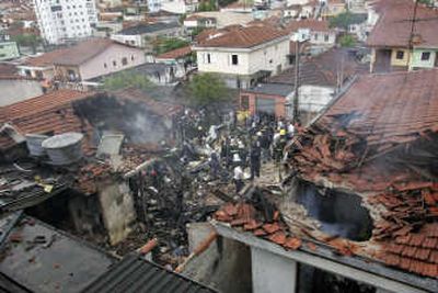 
Firefighters work on the site where a small jet crashed in Sao Paulo on Sunday,  killing at least eight people. Associated Press
 (Associated Press / The Spokesman-Review)