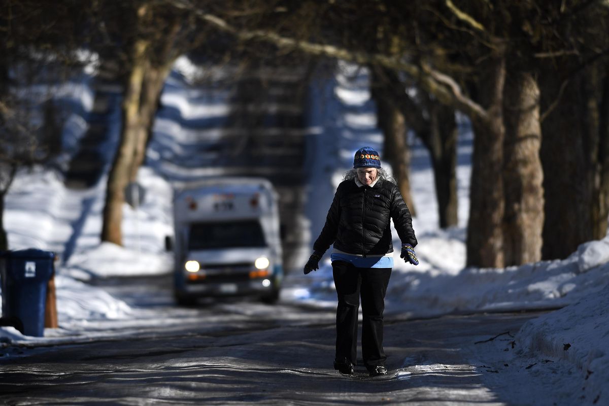 On a walk, Teresa Pisani navigates an icy West 21st Avenue, Weds., Feb 1, 2017, on Spokane’s South Hill. “Our side-street hills are pretty darn slippery,” Pisani said. (Colin Mulvany / The Spokesman-Review)