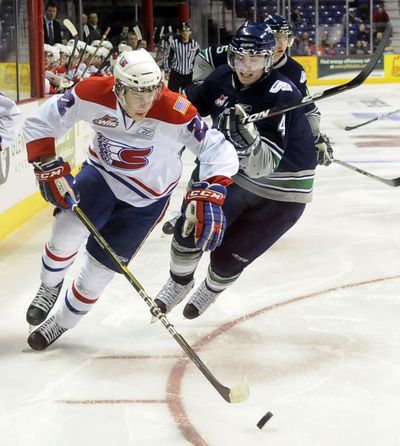 Chiefs' Darren Kramer fends off a charging Erik Bonsor of Seattle as they chase the puck in the first period on Feb. 23, 2011, in Spokane, Wash. (Dan Pelle / The Spokesman-Review)