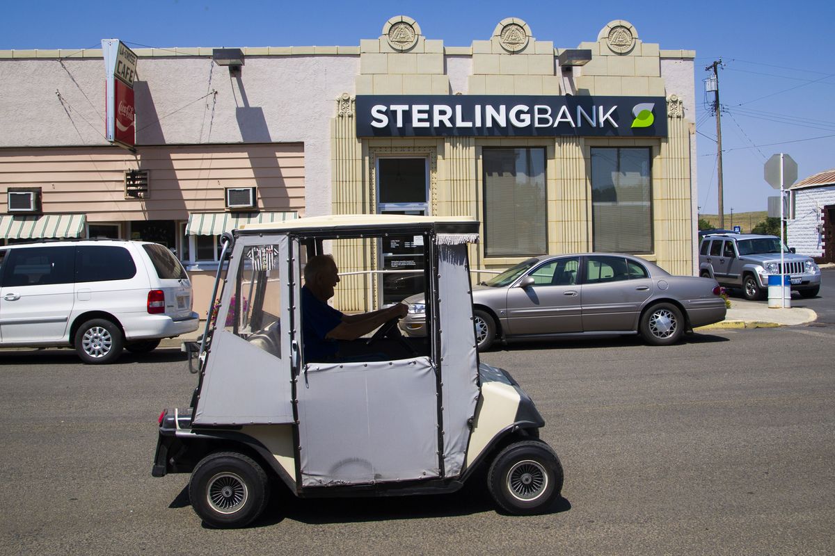 Bruce Kyllo, of LaCrosse, drives his golf cart through town on Wednesday. LaCrosse was on the verge of dying, but an active group of community leaders is helping the town bounce back. It again has a bank and a cafe, and is looking for tenants for a restored building. (Colin Mulvany)