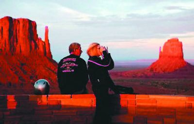 
A couple, with the Mittens in the background, scan the mesas, buttes and arches of Monument Valley. Tour buses take visitors off the beaten track for a back-country look at ancient petroglyphs. 
 (Los Angeles Times / The Spokesman-Review)