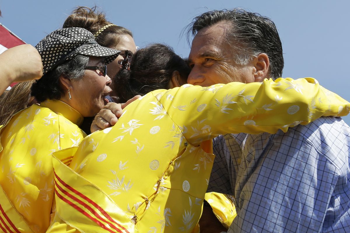 Republican presidential candidate, former Massachusetts Gov. Mitt Romney embraces women wearing traditional Vietnamese "ao dai" dresses as he campaigns at Van Dyck Park in Fairfax, Va., Thursday, Sept. 13, 2012. (Charles Dharapak / Associated Press)
