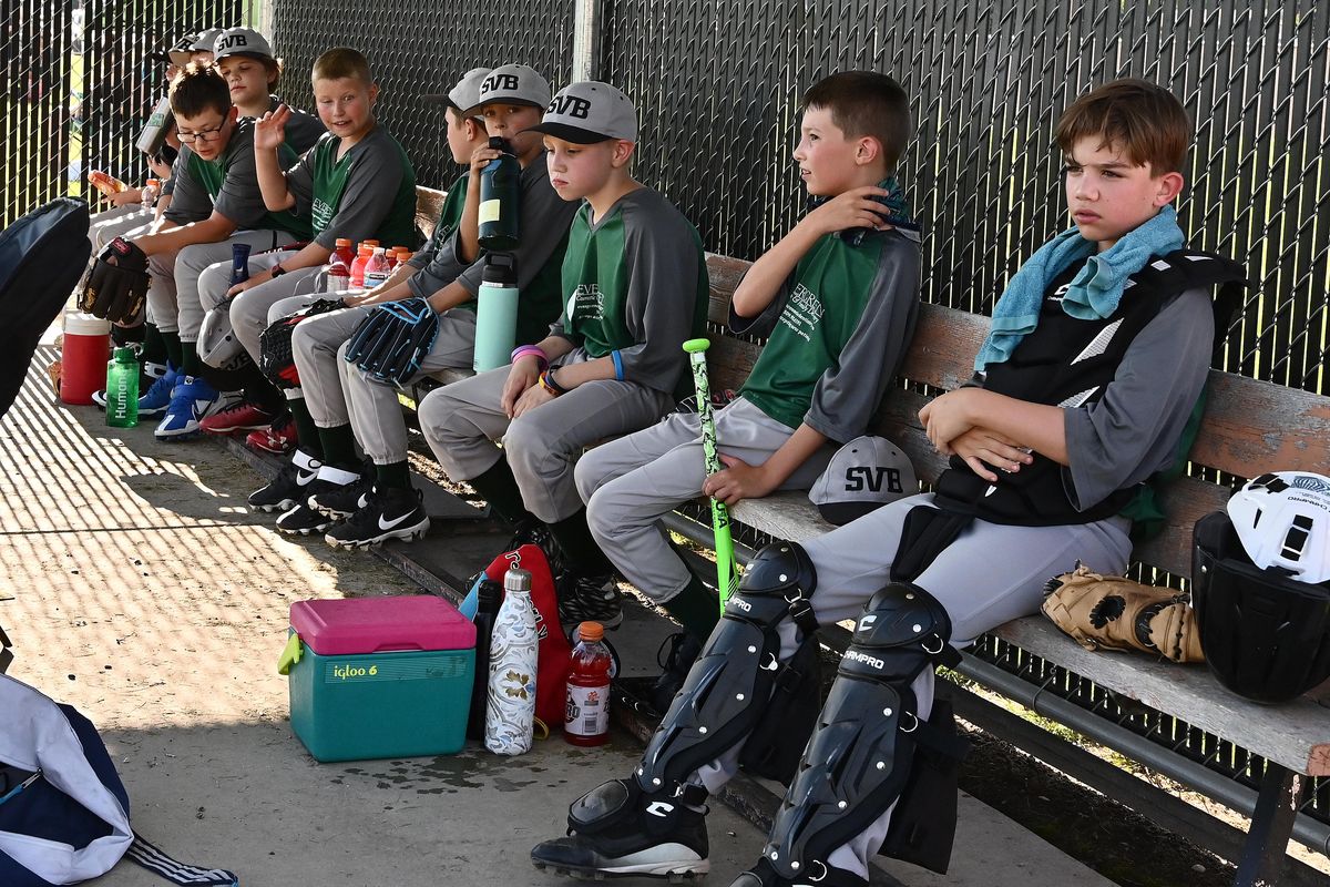 University Elementary baseball team sit in the dug out before the Spokane Valley Baseball Championship game against Broadway Elementary at West Valley High School on Wednesday July 27, 2022.  (James Snook For The Spokesman-Review)