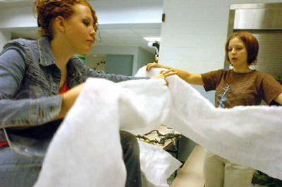 
Volunteers Ashley Wallace, left, and Aliah Lynn sort out white batting to use as winter-themed decorations while setting up for the SNR prom.  
 (Jesse Tinsley / The Spokesman-Review)