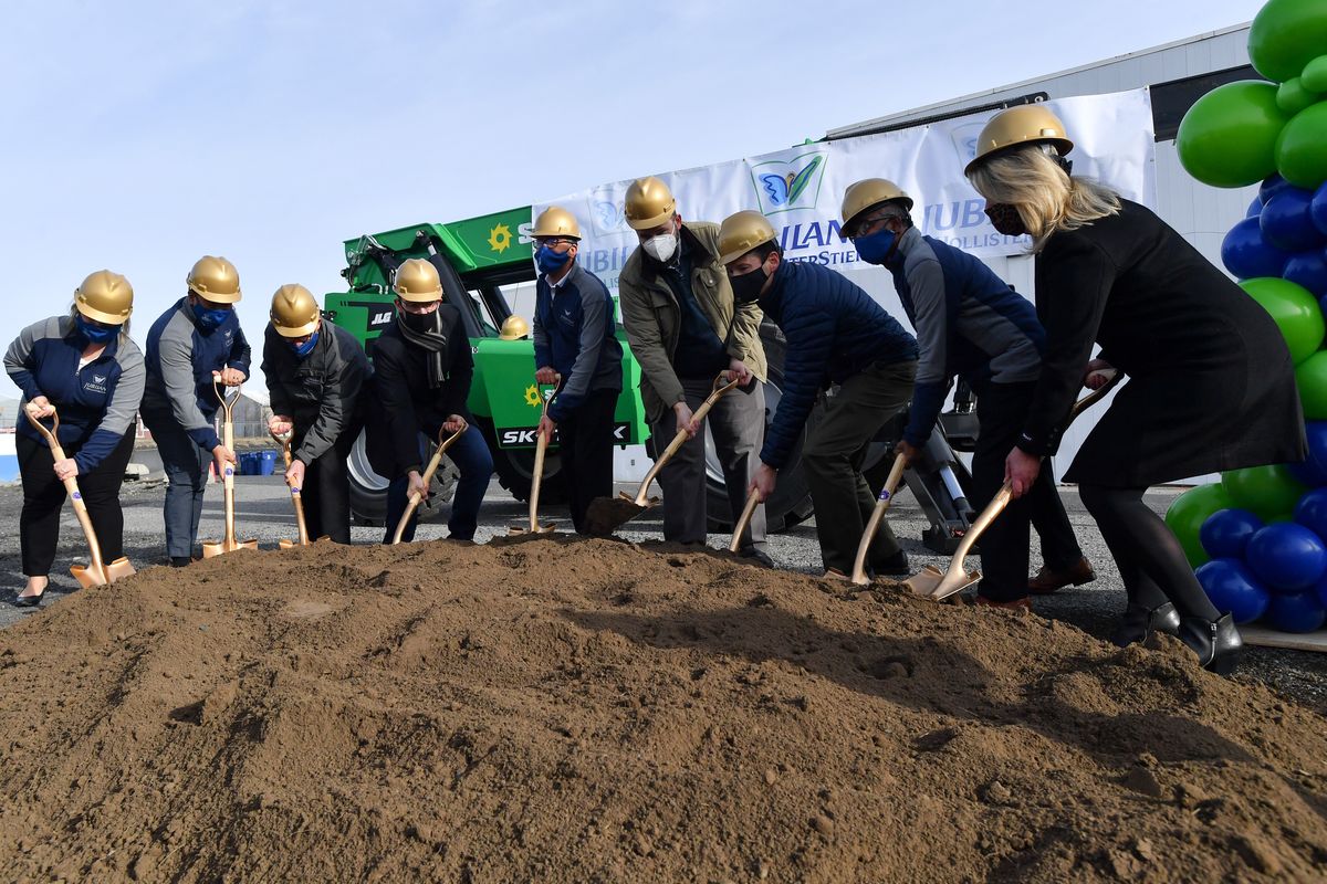 Amit Arora, president of Jubilant HollisterStier, center with blue mask, joins dignitaries, politicians and staff as they break ground Wednesday for the company’s expansion in Spokane.  (Tyler Tjomsland/The Spokesman-Review)