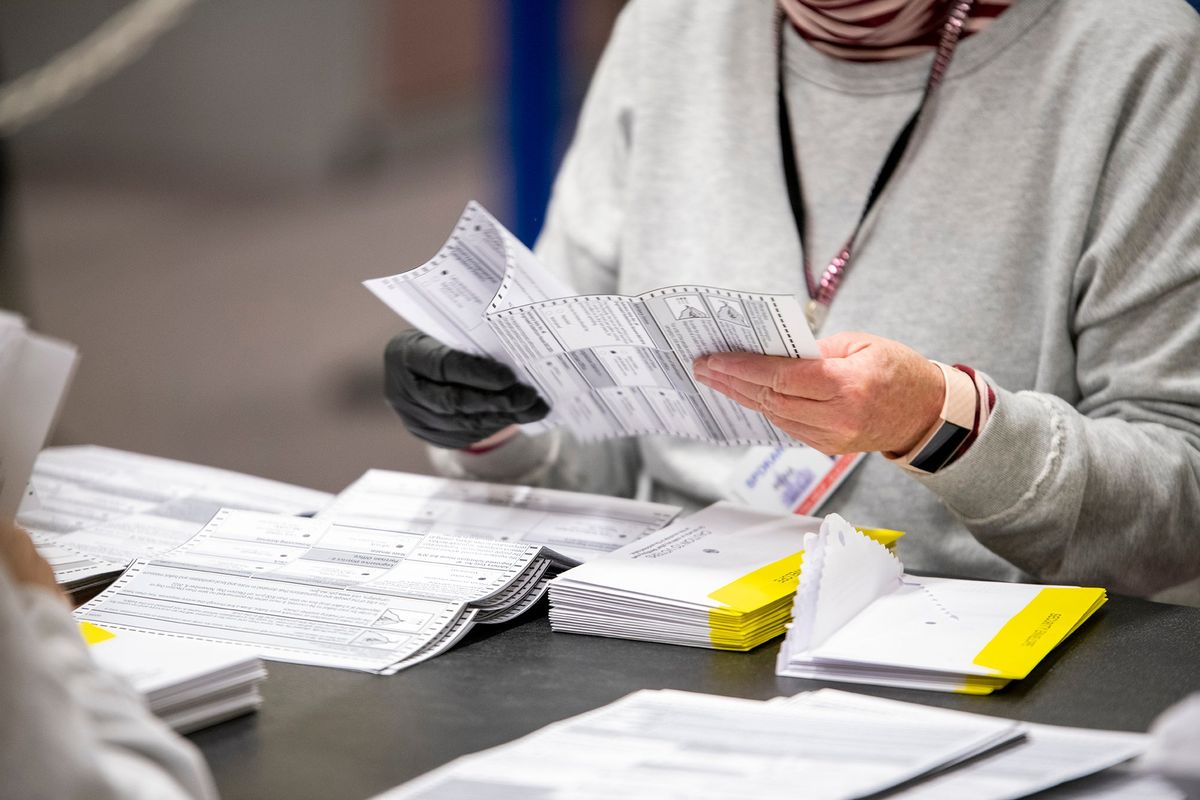 Election worker Renaa Wittkopf opens the interior envelopes to reveal ballots from Tuesday