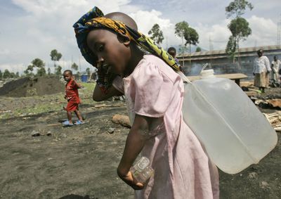 A girl carries water she collected in a camp for displaced people Monday in Kibati, just north of Goma in eastern Congo. Congo’s army clashed with rebels in some of the worst fighting in a week despite the rebel leader’s promise to support a cease-fire, the United Nations said Monday.  (Associated Press / The Spokesman-Review)
