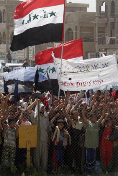 
Residents of Baghdad's mostly Shiite district of Sadr City rally against federalism behind a fence Friday. 
 (Associated Press / The Spokesman-Review)