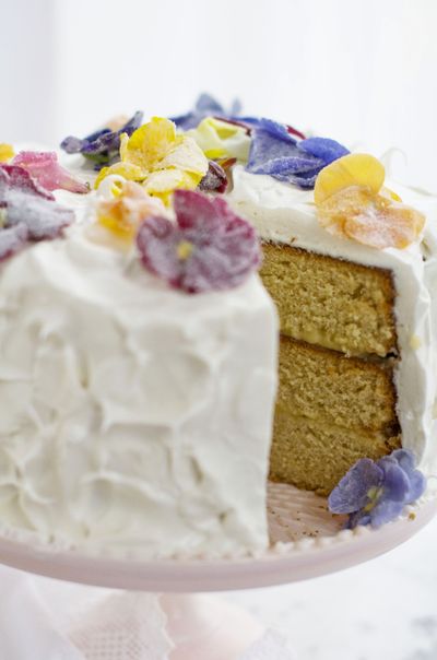 Lemon honey triple-layer cake is topped with edible flowers. Most grocers sell edible flowers with the herbs in the produce section. (Associated Press)