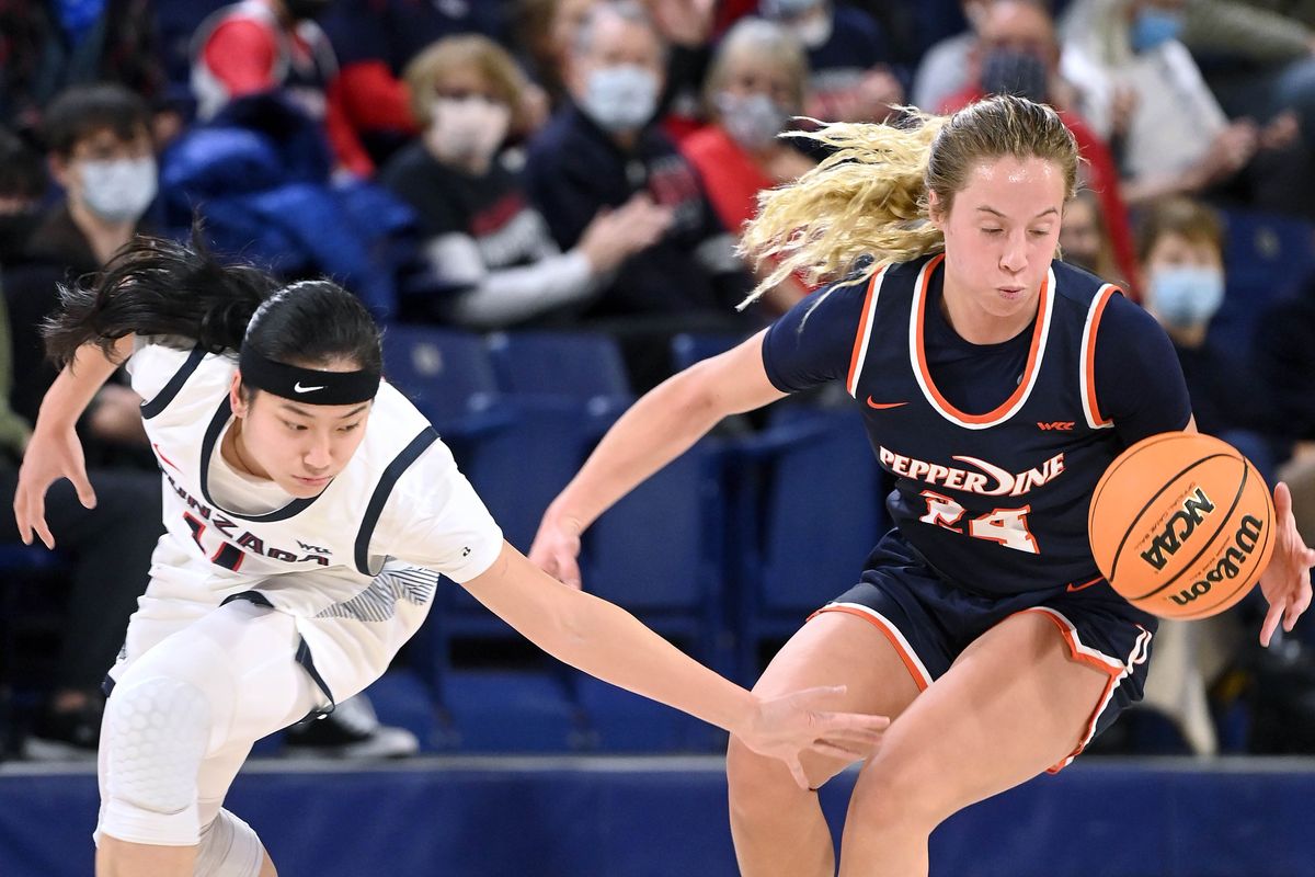 Gonzaga guard Kaylynne Truong (14) and Pepperdine guard Ally Stedman (24) chase a loose ball during an NCAA college basketball game, Thursday, Feb. 24, 2022, in the McCarthey Athletic Center.  (COLIN MULVANY/THE SPOKESMAN-REVIEW)