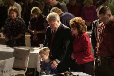 Pastor Robert Keneally stands in prayer with his wife Louise and his grandson Hunter Ragland, 5, during the Grace Harvest Fellowship Christmas worship Sunday.
(Liz Kishimoto / The Spokesman-Review)