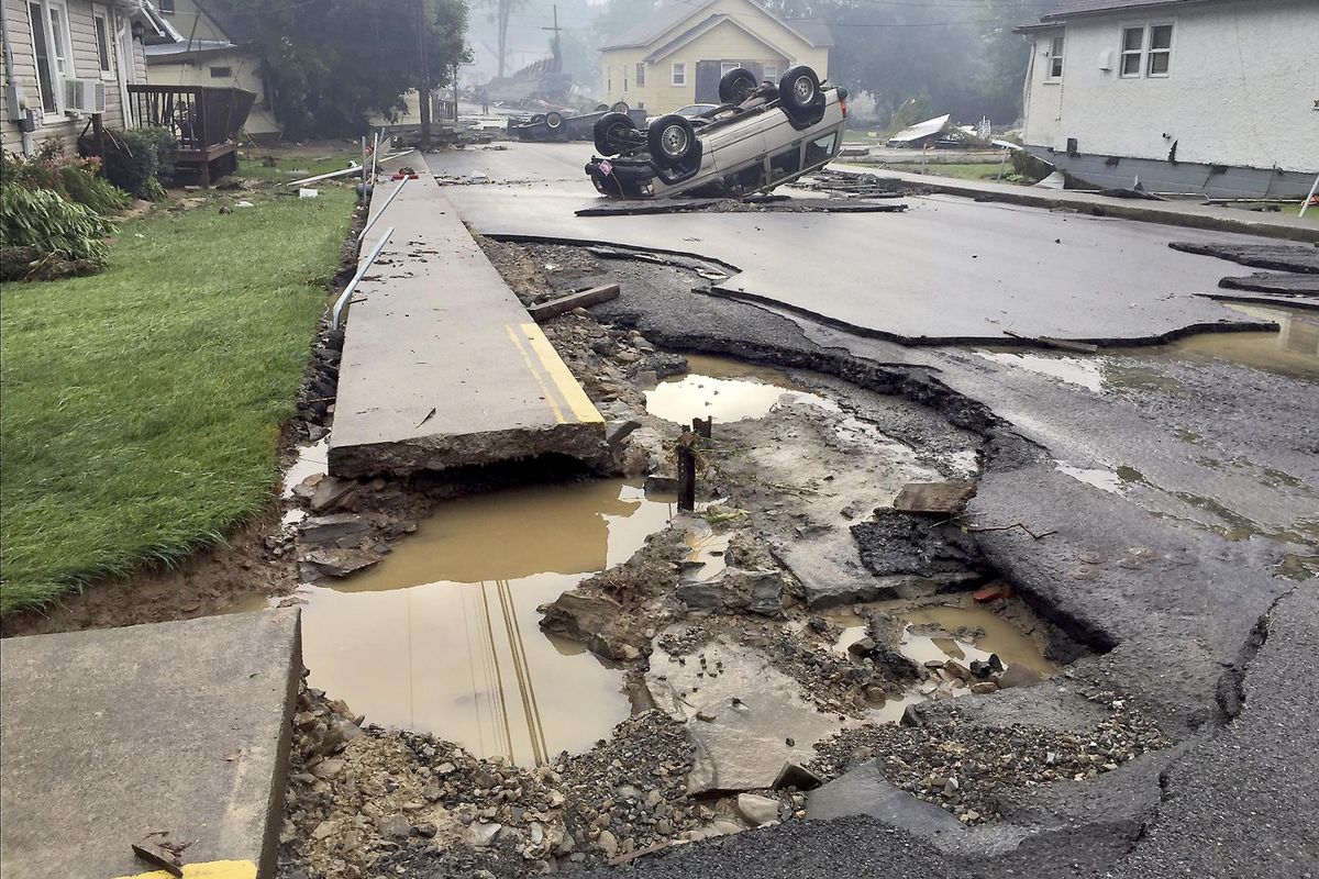A vehicle rests on the roof after flooding near White Sulphur Springs, W.Va., Friday, June 24, 2016. Multiple fatalities have been reported in flooding that has devastated parts of the state, a state official said Friday morning. The fatalities included at least one child and one adult. (Justin Michaels / The Weather Channel via Associated Press)