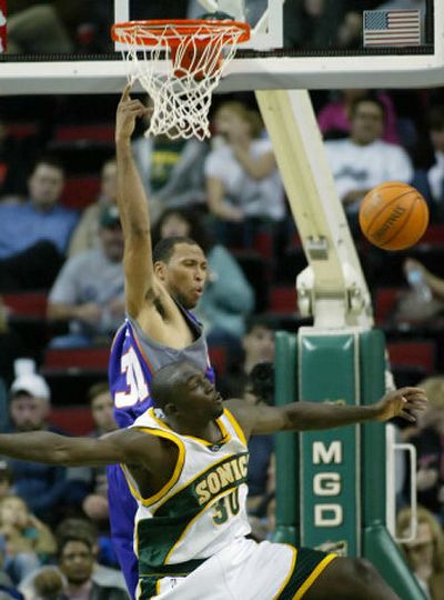 
Seattle SuperSonics' Reggie Evans (30) fouls Phoenix Suns' Shawn Marion on a dunk attempt during the second quarter.
 (Associated Press / The Spokesman-Review)