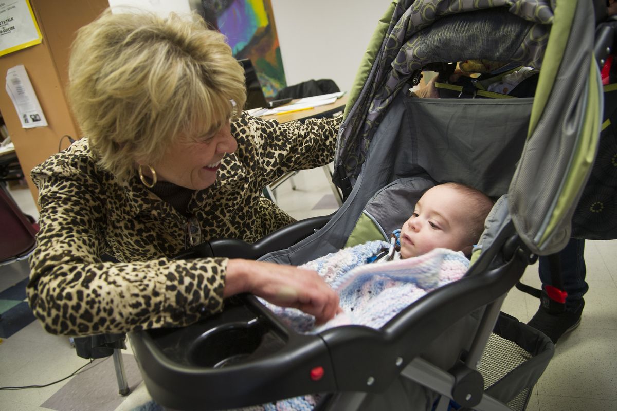 Marilee Roloff, president and CEO of Volunteers of America of Eastern Washington and Northern Idaho, says hello to a Crosswalk Teen Shelter client’s 5-month-old son Riley on Wednesday. Crosswalk is scrambling to maintain vital services after federal grants were cut. (COLIN MULVANY photos)