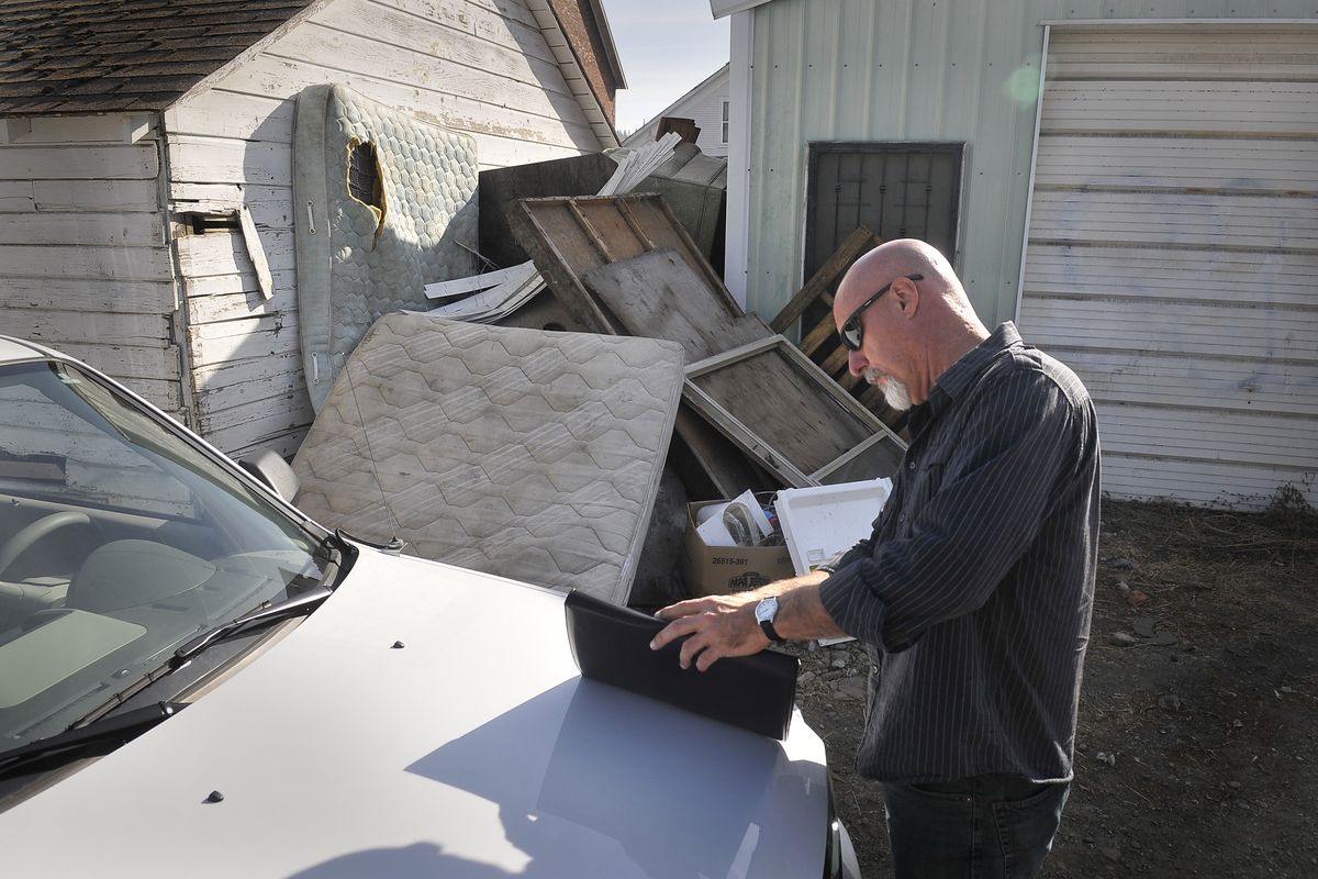 Spokane code enforcement officer Craig Brenden looks at forms pertaining to the pile of refuse in an alley in East Central Spokane on Tuesday. The city trains volunteers to help the department identify areas that need to be cleaned up. (Jesse Tinsley)