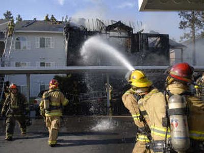 
Firefighters attack a hot spot on the second floor of the Biltmore Apartments on Friday on the South Hill. About 40 firefighters responded to the blaze, which gutted four of the building's 12 apartments. No one was injured, a fire official said. 
 (Photos by Dan Pelle / The Spokesman-Review)