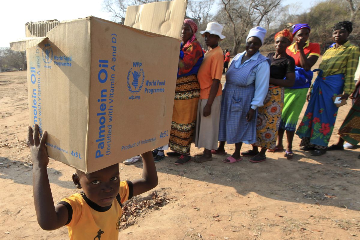 FILE - In this Sept. 9, 2015 file photo, a child carries a parcel from the United Nations World Food Program (WFP) in Mwenezi, Zimbabwe. The WFP has won the 2020 Nobel Peace Prize for its efforts to combat hunger and food insecurity around the globe. The announcement was made Friday Oct. 9, 2020 in Oslo by Berit Reiss-Andersen, the chair of the Nobel Committee. (Tsvangirayi Mukwazhi)