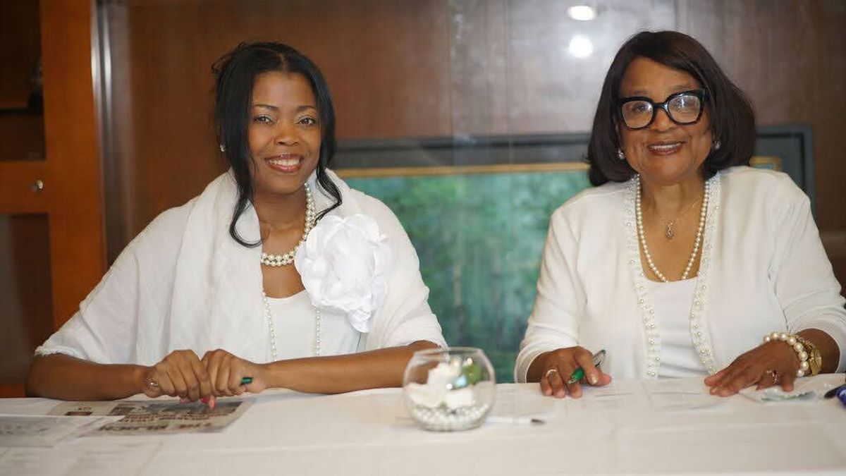 Lisa Gardner and Dr. Jeanne Baynes work the registration table at the Links’ White Rose Brunch.  (Courtesy)