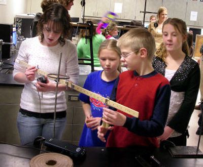 
University High School senior, Rachel Simmons, left, shows Tori Hendricks' Sunrise Elementary fourth graders (left to right) Keely Weisbeck, Tyler Ward and Robbi Quinn, how to use levers and weights to create enough force to move the weights closer to or further away from the fulcrum. The students were performing the experiment at University High School's science lab.
 (Courtesy of Melanie Rose / The Spokesman-Review)