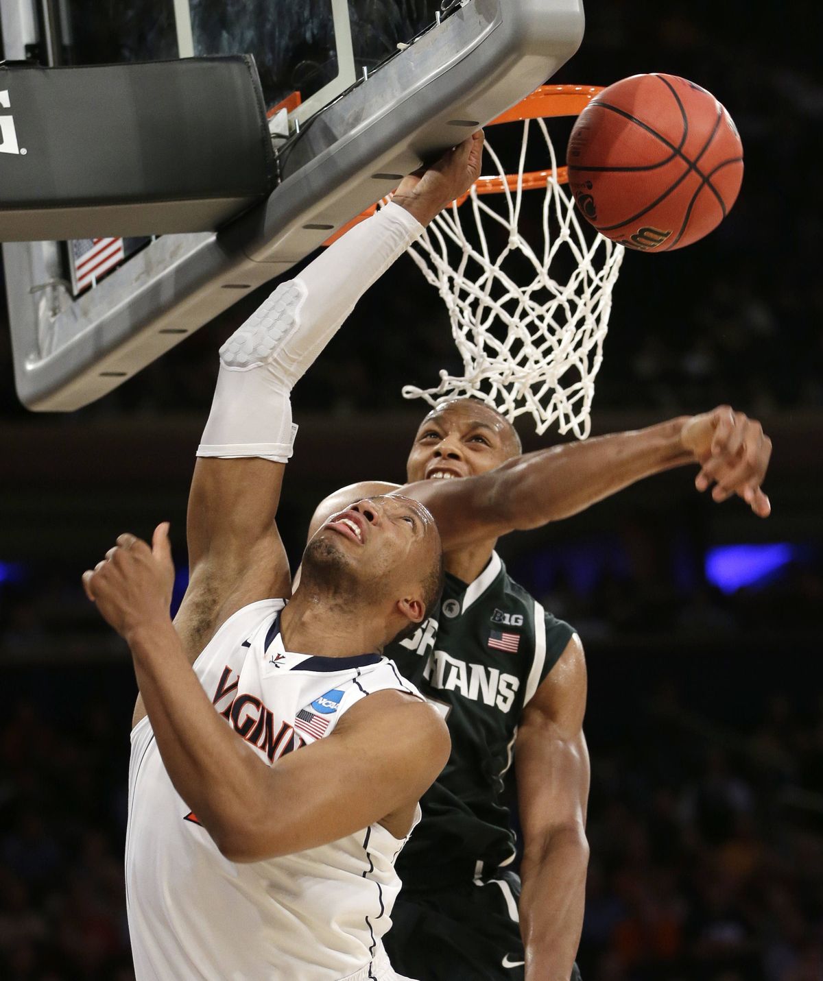 Michigan State’s Adreian Payne, right, blocks a shot by Virginia’s Akil Mitchell during the second half. (Associated Press)