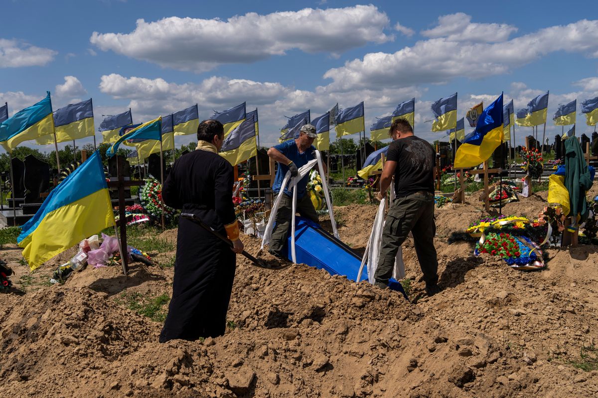 Undertakers lower the coffin of Ukrainian serviceman Oleksander Matyukhin, 32, in Kharkiv, Ukraine, on Monday.  (Bernat Armangue)