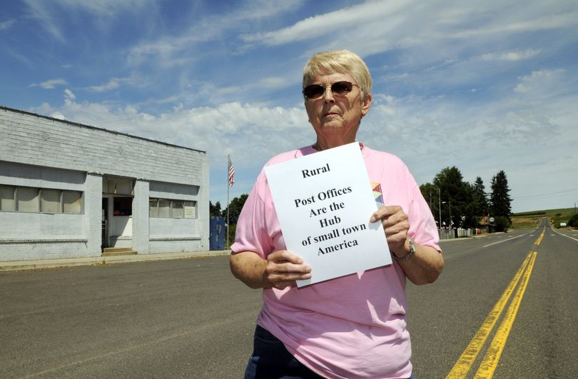 Town Council member and resident historian Evelyn Heinevetter has printed signs in support of the town’s post office building, to the left, in Waverly. Waverly is among about 2,500 small and rural towns with post offices targeted for closure by the USPS. (Dan Pelle)