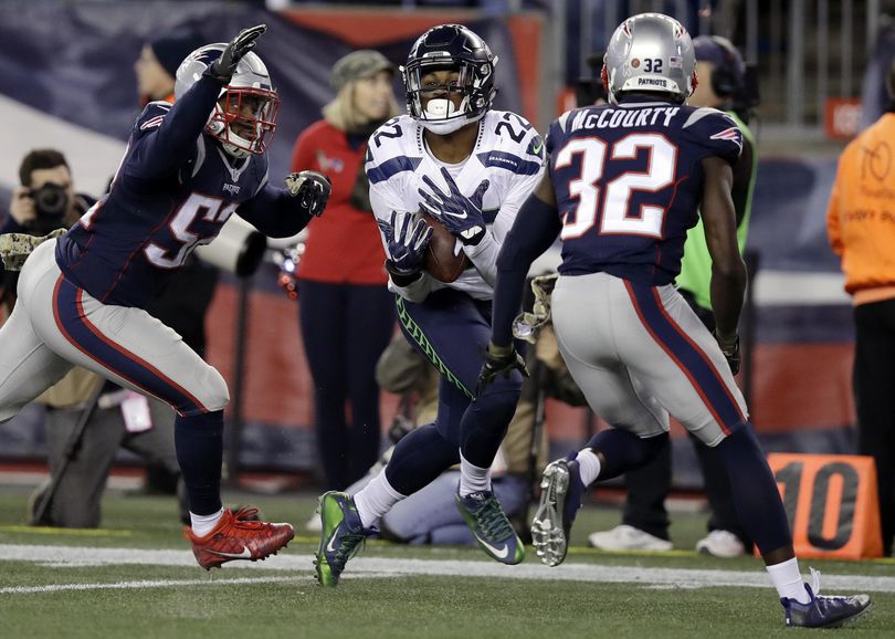 Seattle Seahawks running back C.J. Prosise (22) catches a pass between New England Patriots defenders Elandon Roberts, left, and Devin McCourty (32). (Charles Krupa / Associated Press)