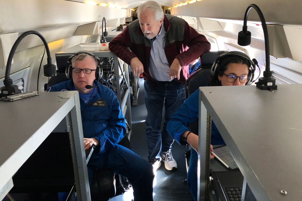 Marty Ralph, center, watches as meteorologists Rich Henning, left, and Sofia de Solo track data while flying above an atmospheric river over the Pacific Ocean.  (Ian James/Los Angeles Times/TNS)