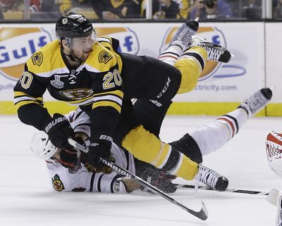 Chicago’s Niklas Hjalmarsson, bottom, takes down Bruins left wing Daniel Paille in second period. Paille scored one of two Boston goals. (Associated Press)