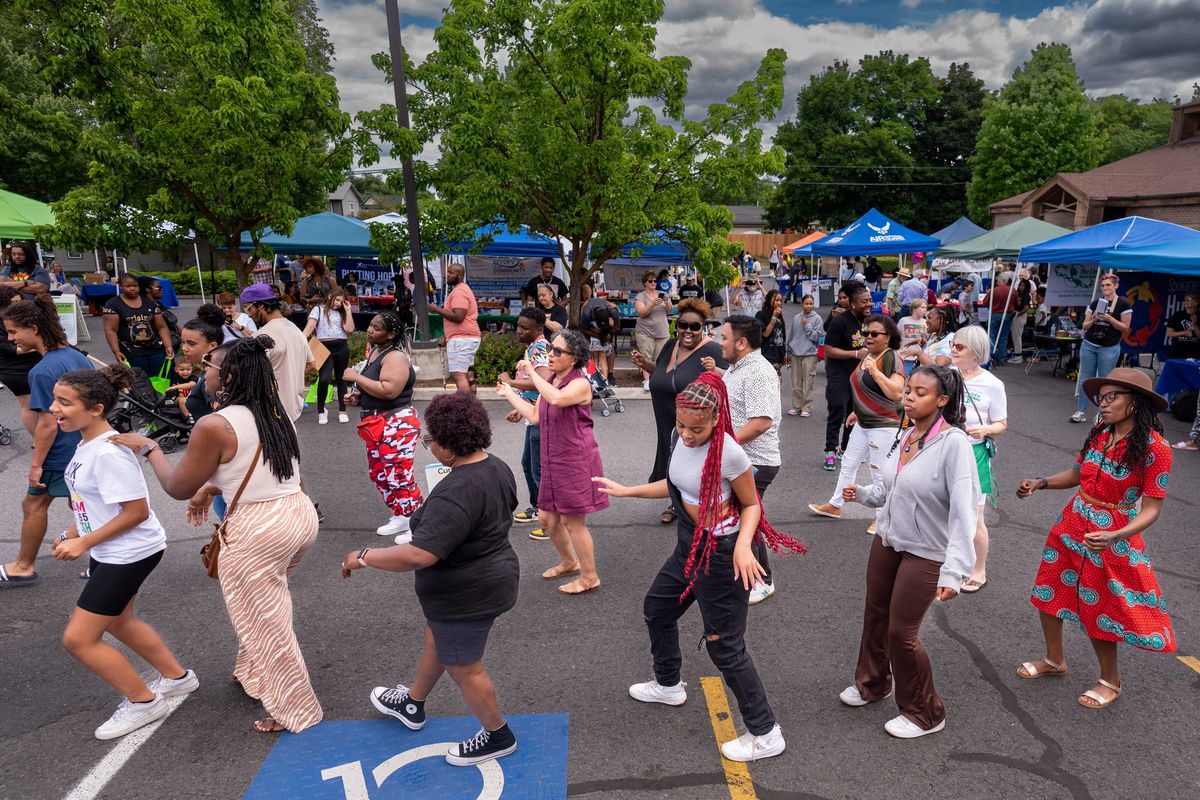 People dance the Cupid Shuffle during the Dr. Martin Luther King Jr. Community Center’s Juneteenth Celebration on Saturday, June 17, 2023. The event held in the center’s parking lot featured community partner booths, live music, food, giveaways and games.  (COLIN MULVANY/THE SPOKESMAN-REVI)