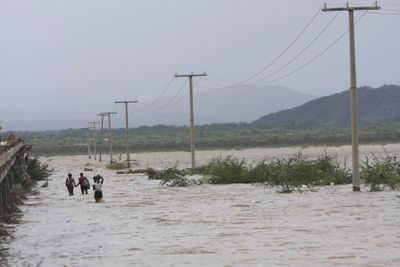 People walk through flood water from Tropical Storm Hanna, in Savane Desole,  northern Haiti, on Tuesday.  (Associated Press / The Spokesman-Review)