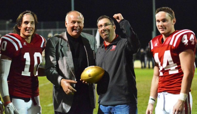 Former NFL standout Jerry Kramer presents the NFL’s Golden Ball to Athletic Director Kris Knowles. Kramer graduated from Sandpoint High School before starring for the Idaho Vandals and the Green Bay Packers. (Lauren Sfeir/Sandpoint High Cedar Post photo)