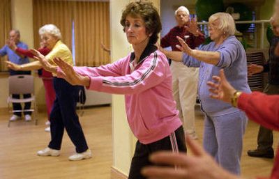 
Rita Doran concentrates on a new move during the Tai Chi class for seniors at Rockwood South Retirement Community. Below, Mary Janes Bates, left, and Carol Mitchell share a laugh while warming up for class.
 (LIZ KISHIMOTO Photos / The Spokesman-Review)