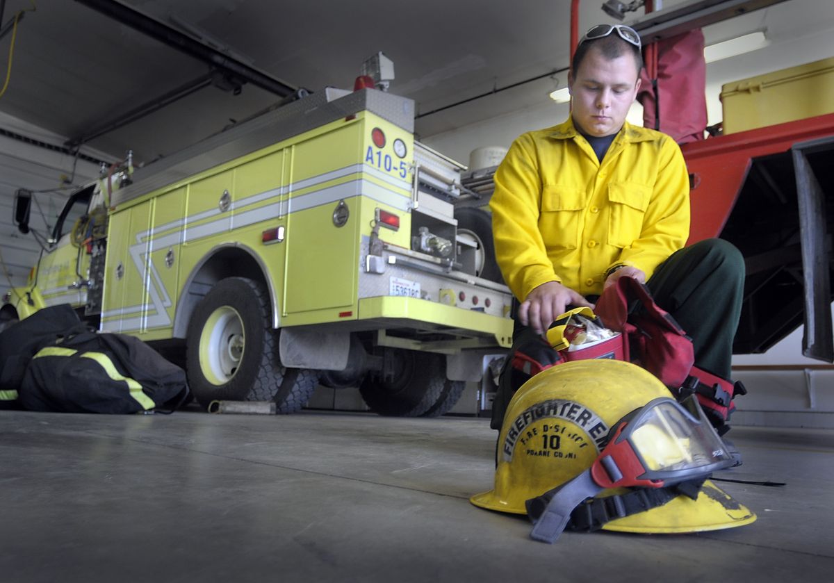 Fire District 10 resident volunteer Marty Shier checks his gear before starting his shift. (CHRISTOPHER ANDERSON / The Spokesman-Review)