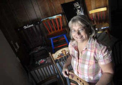 
Pam Almeida, director of Spokane Valley Meals on Wheels, stands  with a few of the chairs painted by area  artists that will be auctioned to benefit the program Nov. 30.
 (Photos by HOLLY PICKETT / The Spokesman-Review)