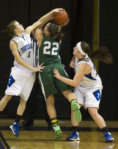 Toutle Lake guard Britzy Hockett (1) blocks a shot by Northwest Christian guard Treasure Farmer (22) during the second half of a WIAA State 2b Girls basketball game, Friday, March 7, 2014, in the Spokane Arena. (Colin Mulvany / The Spokesman-Review)