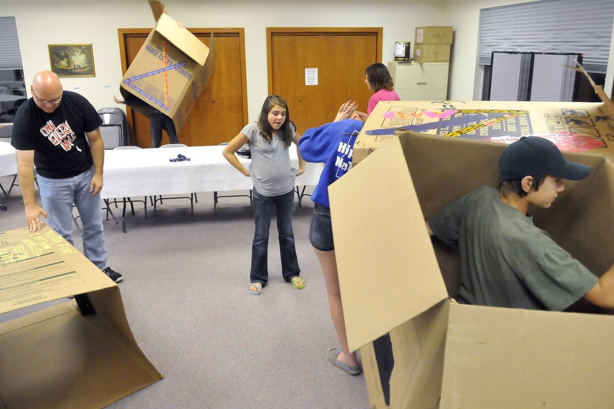 Darren Boik, 14, right, plans to spend Friday night out with other church youths and parents in a cardboard box he decorated on Monday at St. Joseph’s Catholic Church in Otis Orchards. The campers aim to raise awareness about the homeless in Spokane. (Jesse Tinsley)