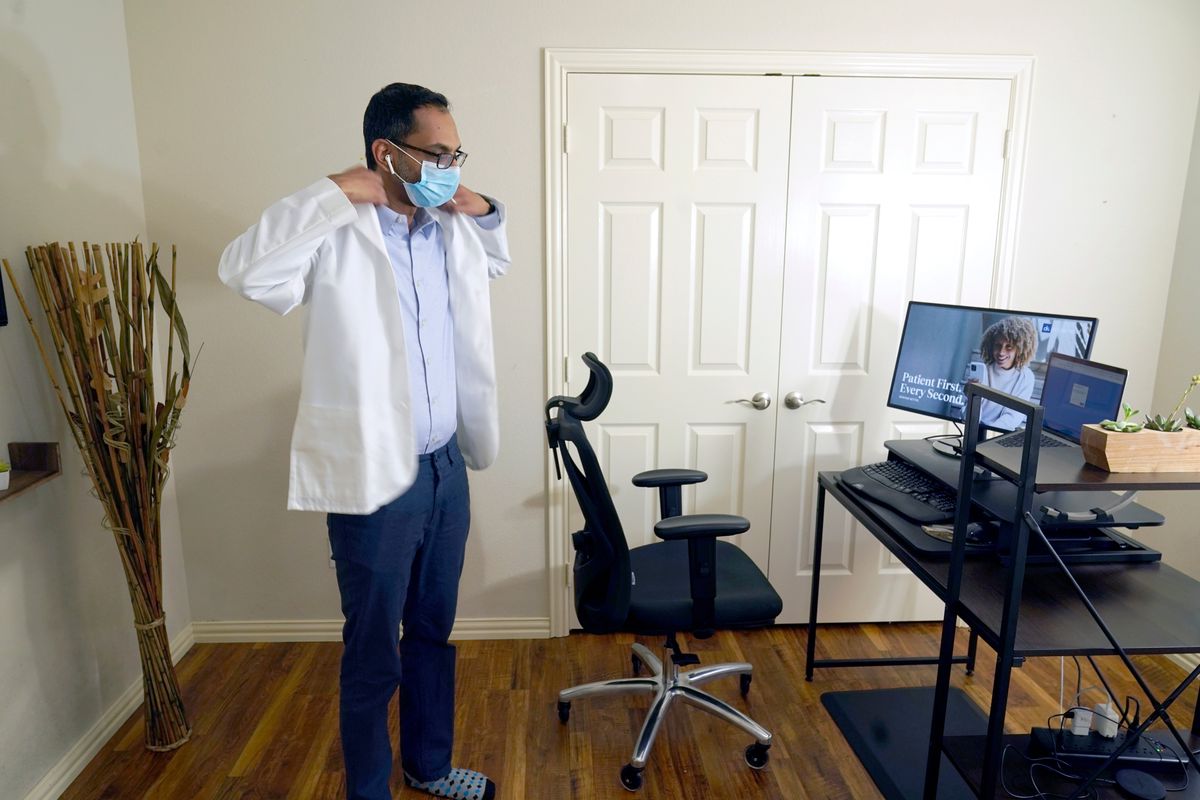 Medical director of Doctor on Demand Dr. Vibin Roy prepares to conduct an online visit with a patient from his work station at home on April 23 in Keller, Texas. (LM Otero)