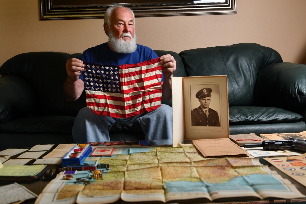Army history buff Jon Franklin poses for a photo with a collection of World War II memorabilia brought back from D-Day by 1st Lt. Charles Kidder, Company G, 2nd Battalion, 8th Infantry Division on Thursday, June 13, 2019, at his home in Spokane Valley, Wash. (Tyler Tjomsland / The Spokesman-Review)