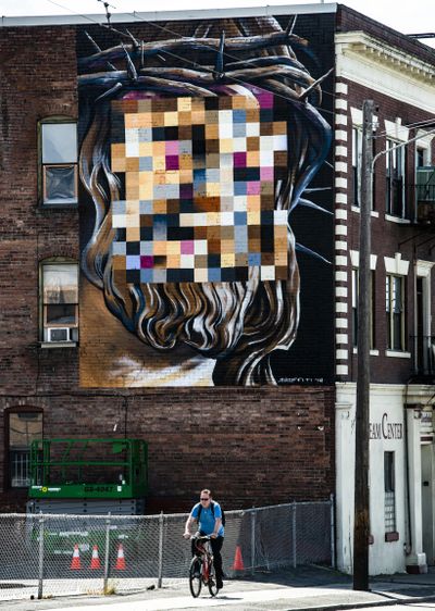 A mural featuring the pixelated face of Jesus  painted on the side of a Second Avenue building is the latest offering from local artist Daniel Lopez. (Colin Mulvany / The Spokesman-Review)
